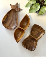 Overhead view of all three vintage wooden trinket holders showing unique carved shapes and wood grain.