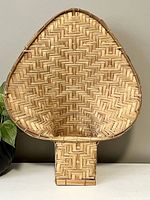 Full view of the woven peacock plant holder showing the shape and weaving pattern