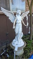 Full front view of resin angel statue on urn pedestal