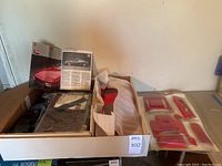 Overview of entire unassembled kit in cardboard tray showing metal body, panels, sprues, and booklet
