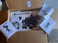 Opened shipping box showing foam-packed CGE Series mount components, manual, cables and counterweight shaft