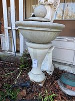 Full elevation view of concrete fountain showing round finial atop basin and flared pedestal base