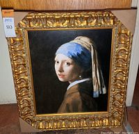 Framed art reproduction of Girl With The Pearl Earring by Jan Vermeer, with ornate gilded frame.
