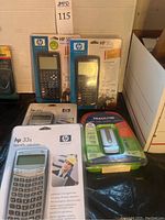 Group view: two HP 50g graphing calculators, one HP 33s calculator, one HP 33s calculator overlapping, Tracfone phone