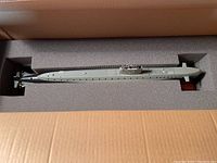 Submarine model in original foam-lined packaging box showing full length of hull.
