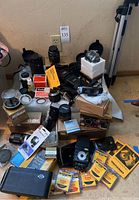Overview of lot showing multiple lenses, filters, teleconverters, flash unit, duplicator and cases