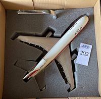 Top-down view of model airplane and display mount inside foam packaging