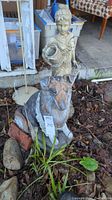 Front view of seated collie statue and standing garden girl statue side by side