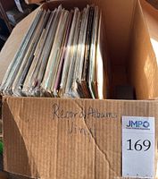 Cardboard box with handwritten “Record Albums Vinyl” label showing a large stack of albums.