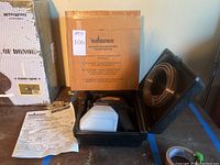 Factory reconditioned Wagner power painter in case with paint container and instruction manual visible, original box in background.