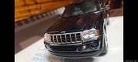Close-up of the front grille of the black metal diecast Jeep SUV model showing details and condition.