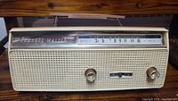 Front view of the cream-colored Channel Master radio, showing the frequency dial, knobs and carrying handle.