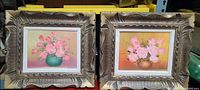 Two framed acrylic floral paintings side by side showing pink flowers and textured decorative gold frames.