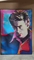 Framed colorful portrait art of James Dean showing his head and shoulders with a modern stylized use of colors including blue, red, pink, and yellow, in good condition.