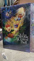 Front view of the sealed vintage 'A Troll in Central Park' movie poster showing colorful animated characters and title.