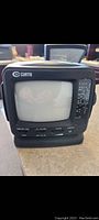 Front view of Curtis vintage mini black and white TV showing the small CRT screen and control sliders.