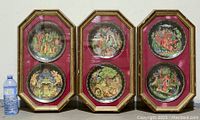 Set of six octagonal wood framed displays, each containing two round decorative plates depicting Russian fairytale scenes, displayed upright next to a water bottle for size reference.