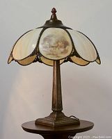Currier & Ives vintage stained glass lamp showing shade, detailed scenic panels, and bronze-tone base.