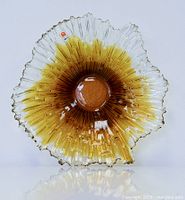 Front view of the textured art glass starburst bowl showing amber center and clear edges with scalloped rim.