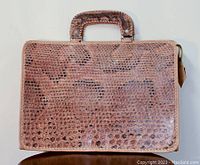 Front view of the vintage alligator/crocodile hide briefcase showing material texture, handle, and overall condition.