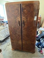 Front view of vintage two-door armoire with wood grain pattern and closed doors.