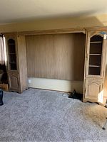 Full view of king bed unit with side cabinets showing the central panel and carpeted floor.