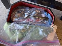 Plastic bags containing metal forks and spoons, some with visible Oneida Ltd. marking
