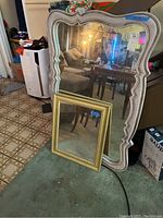 Both mirrors standing upright showing size difference and frame styles.
