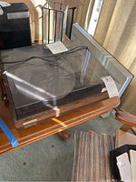 Full view of Pioneer turntable on wooden table, plastic dust cover on, showing overall condition including crack