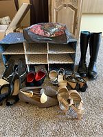 Wide view of the shoe and boot lot including knee-high boots, high heels, and various sizes and styles.