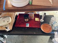Photo of waffle maker, candle, cutting board, glass vases, ceramic plate and puzzle cube on table