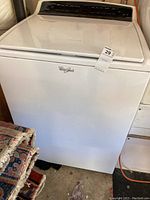Front view of white Whirlpool washing machine with sticker labeled '29'