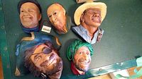 Set of five Bossons hand-painted ceramic wall head ornaments arranged on green surface, showing all character heads.