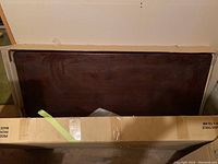 View of dark wood table surface inside the box showing the table top.