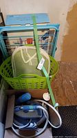 Photo shows the laundry basket, mesh hamper, drying rack, and the steam iron in a box on the floor.