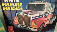 Box art showing White Road Boss semi truck model kit by AMT, red, white and blue colored cab with detailed grille and lights.