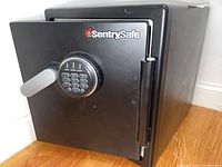 Front view of the black Sentry Safe showing the door, handle, and keypad lock.