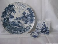 Shot showing all three items together on a white background: Ridgeway hand-engraved ironstone plate, Delft hand-painted tile, and miniature Delftware plate.