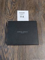 Closed black box with Giorgio Armani Milano logo on lid on wooden surface