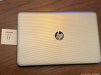 Closed silver HP laptop with textured lid showing HP logo