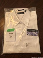 Folded women's white cotton dress shirt in original clear packaging with size and brand tags visible.