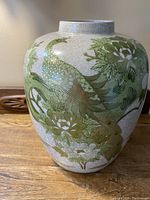 Front view showing hand-painted green floral design with gold leaf accented peacock on crackle glaze porcelain.
