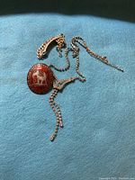 Lot of jewelry pieces on blue fabric: sterling silver brooch with red enamel, 800 silver bracelet, rhinestone necklace