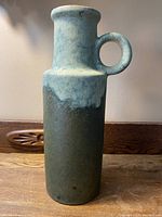 Front view of the vase showing cylindrical shape with handle and blue-green variegated glaze.