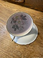 Top view of teacup showing the pink background with detailed floral design inside and gold trimmed rim.