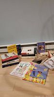 Photo showing a variety of adult and children's books arranged on a surface, titles partially visible.