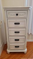 Front view of the white five-drawer lingerie dresser with black handles and knobs