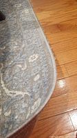 Close-up photo of the edge of one area rug showing pattern, texture, and frayed edge.