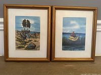 View of the two framed watercolor paintings side by side showing distinct rural and water scenes.