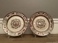Pair of antique B.C. and W. Kioto plates on stands, showing full faces and decorative rims